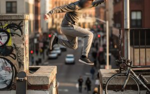 Un adolescent pratiquant le parkour dans un environnement urbain, symbolisant l'indépendance.